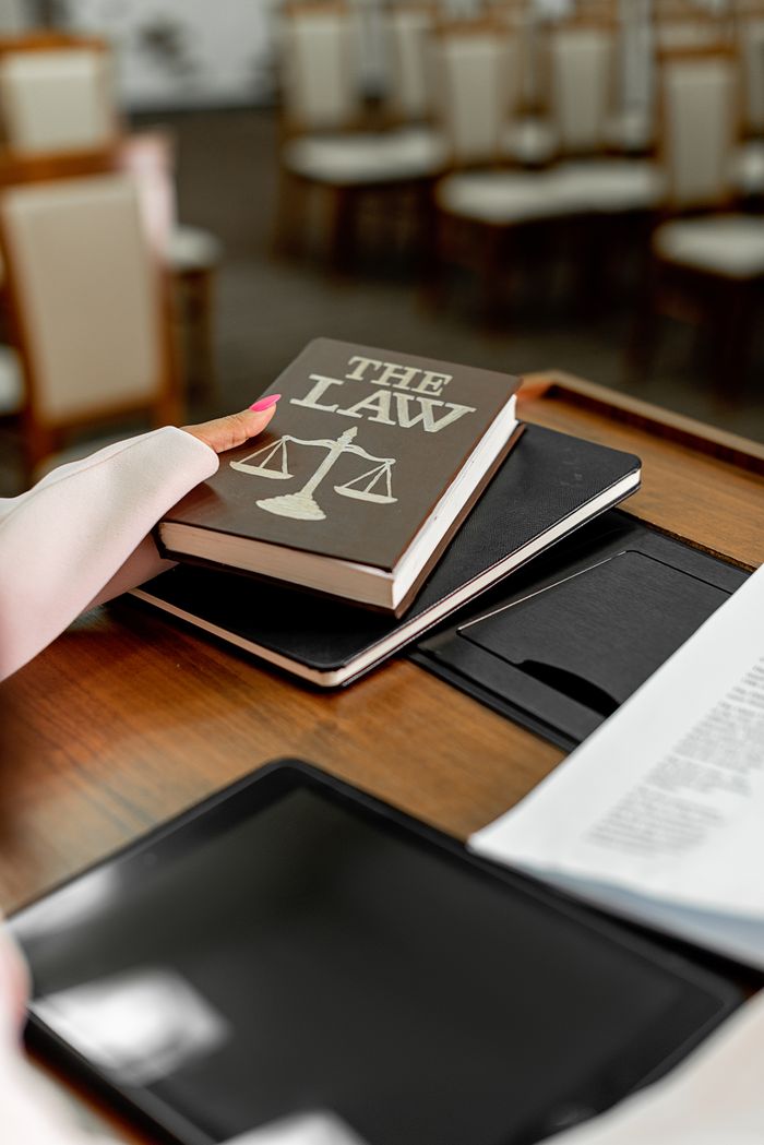 who-we-are Close-up of a law book on a podium in a conference setting, symbolizing legal knowledge.